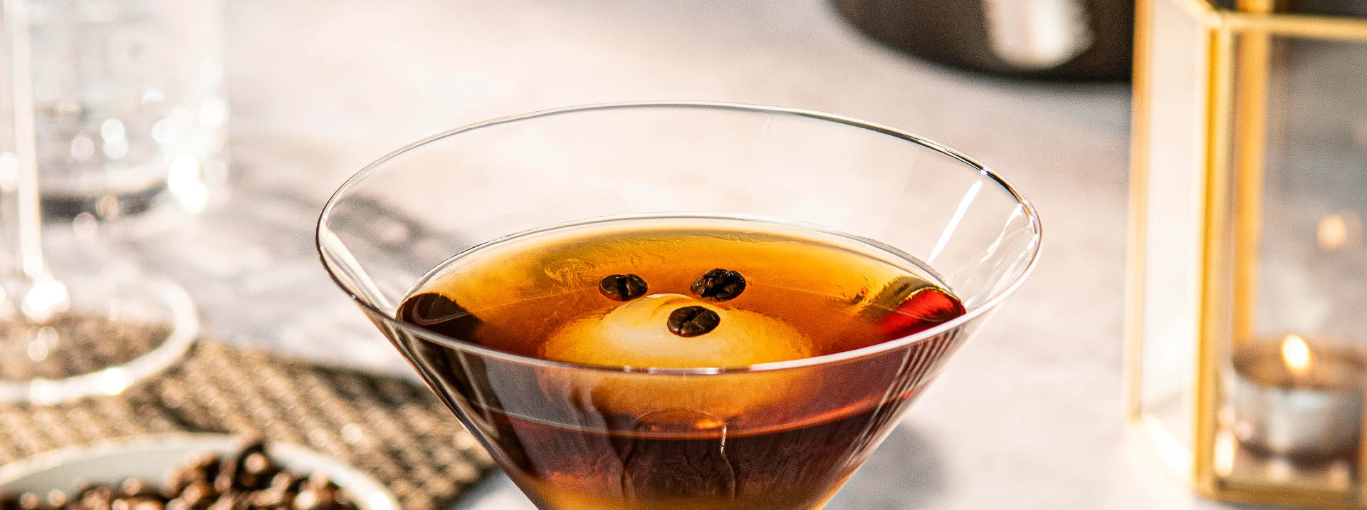 detail of martini glass with coffee cocktail in it and coffee beans